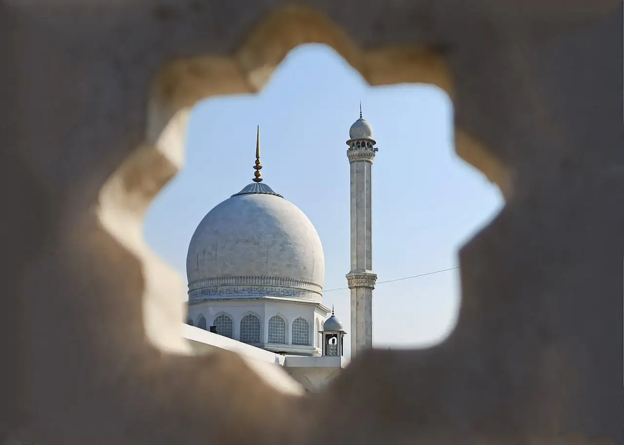 gallery-2 Stunning view of a mosque's dome and minaret seen through a decorative arch, emphasizing Islamic architecture.